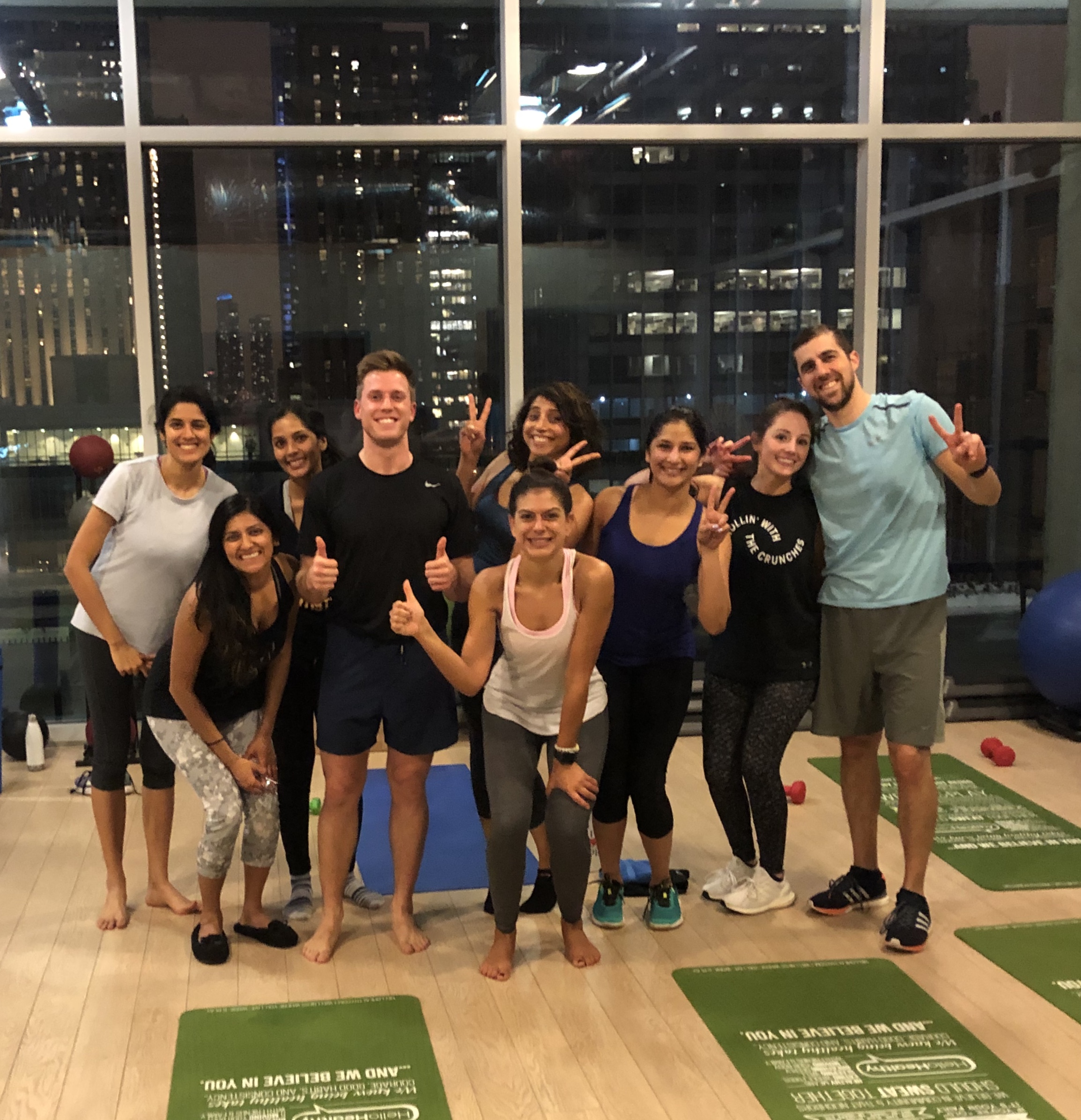 Yoga class with diverse group doing power vinyasa, energetic atmosphere with pink and purple lighting, modern studio